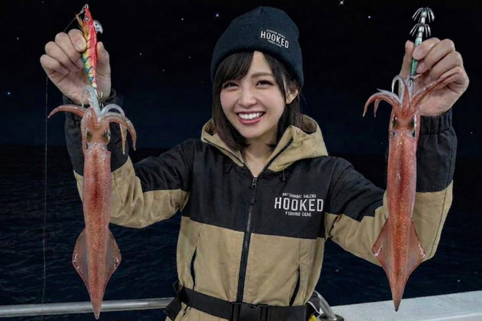 夜の船上でイカメタルの釣果を手にする様子